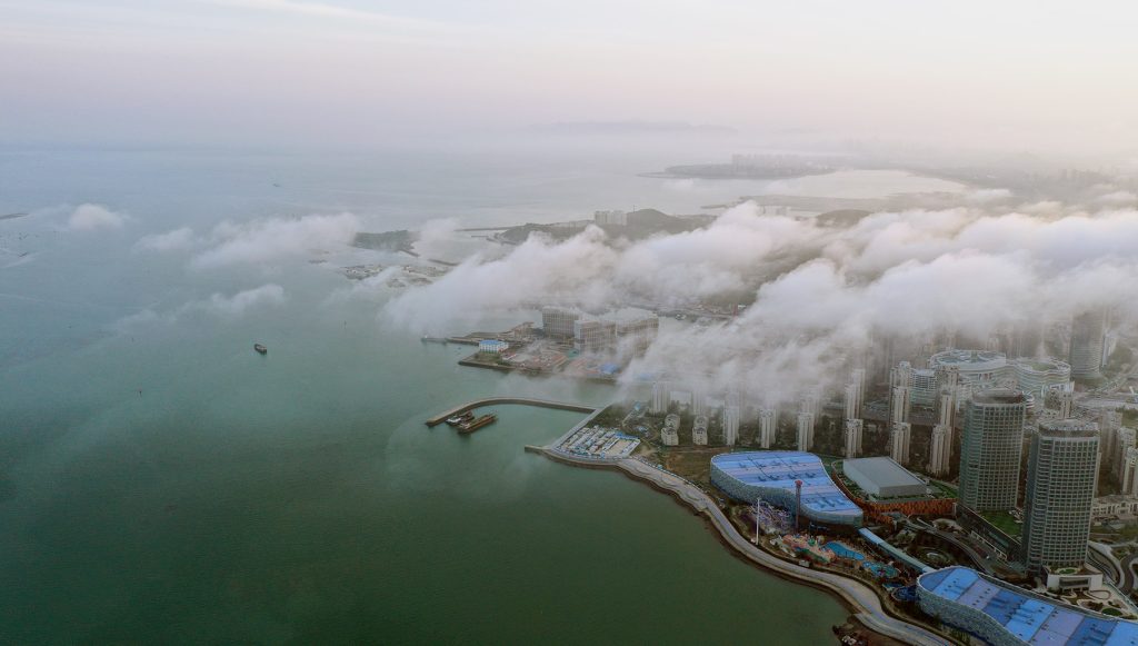 西海岸新区附近海面掀起平流雾